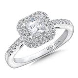 A double halo accentuates the center stone, while a delicate band of pave-set diamonds cascades down the finger.