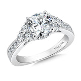 A triangle of diamonds with pinched channel-set shoulders is an elegant mounting design for the stunning center stone.